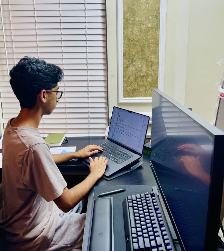 A person on a computer, coding.